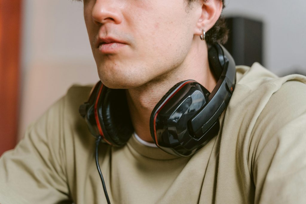 Close-up of a young man wearing a gaming headset while relaxed indoors.